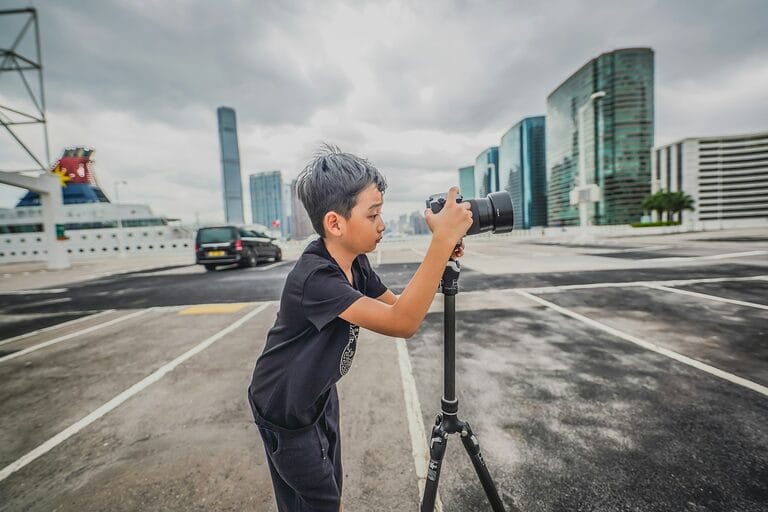 A young boy holds a camera to record video, illustrating the child content creators and vloggers now covered by DOLE's Working Child Permit requirement under RA 9231