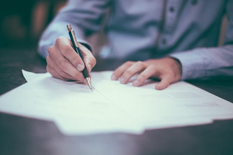Two people reviewing and signing a fixed-term employment contract