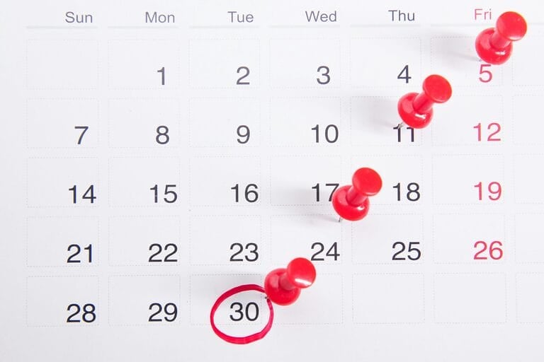 Wall calendar page with red pins marking specific dates, representing the Philippine 2026 regular holidays and special non-working days calendar