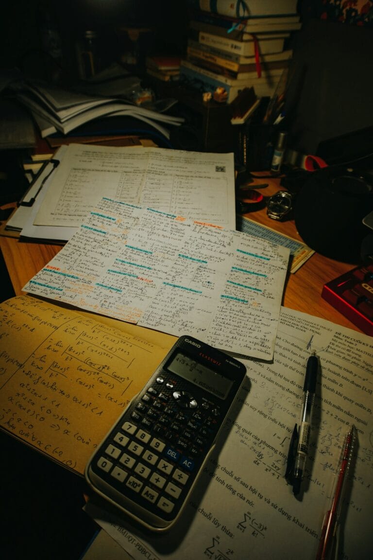 Calculator and papers on a desk used to compute pay according to a salary grade and step, illustrating how the Philippine government's salary schedule sets a civil servant's basic monthly pay