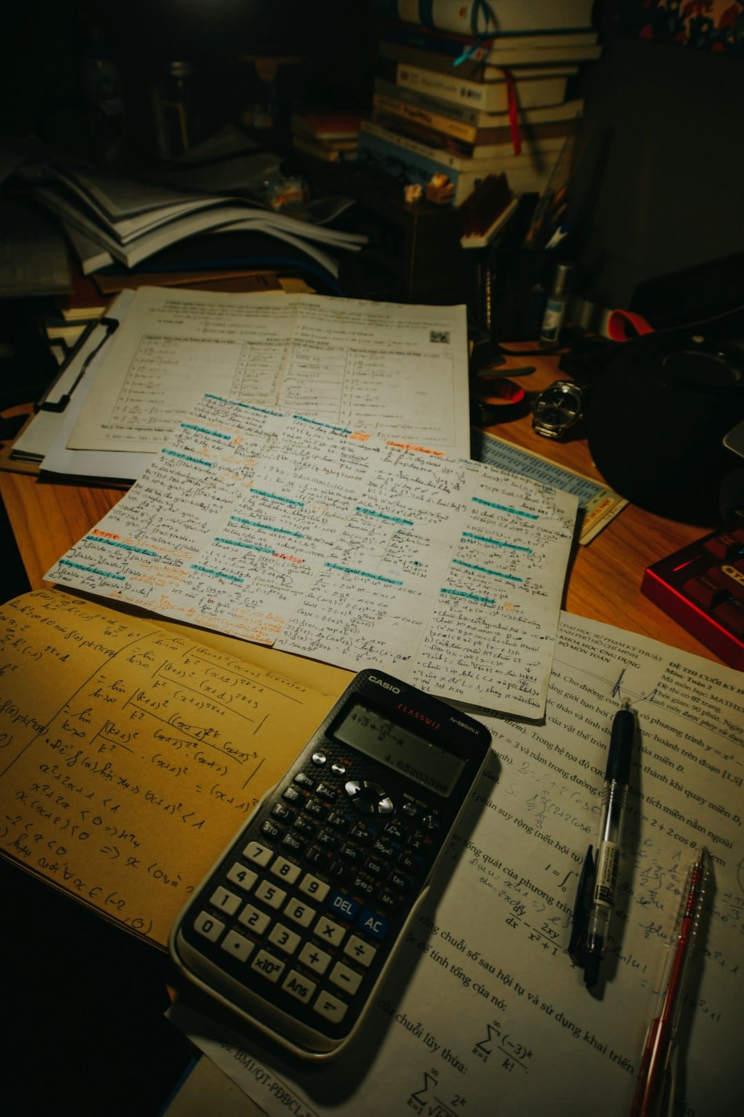 Calculator and papers on a desk used to compute pay according to a salary grade and step, illustrating how the Philippine government's salary schedule sets a civil servant's basic monthly pay