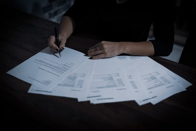 Close-up of an employee signing a non-disclosure and confidentiality agreement document with a pen