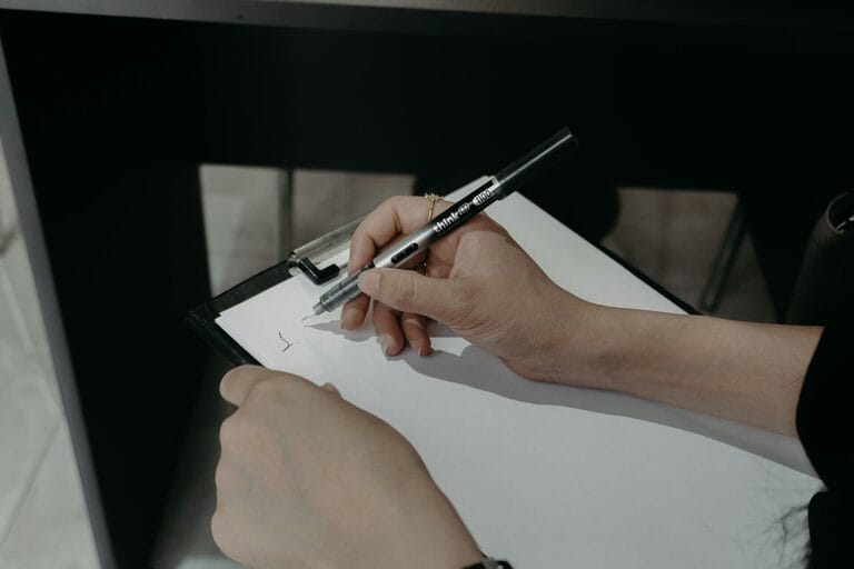 Close-up of hands filling out and signing an official leave certification document, representing the barangay, prosecutor, or Clerk of Court certification an employee submits to avail of the 10-day VAWC leave under RA 9262