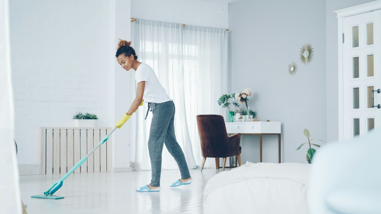 A household worker mopping the floor at home, representing a kasambahay performing domestic work covered by RA 10361