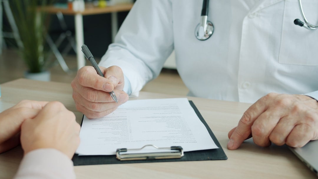 Doctor completing a patient's medical record documenting illness and confinement, the type of medical certificate required to support an SSS sickness benefit claim in the Philippines