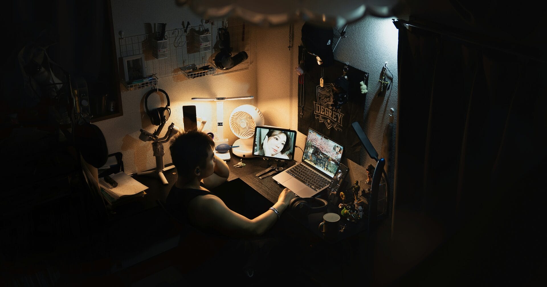 Filipino employee working late on a laptop and phone at night, illustrating moonlighting or a second job outside regular office hours
