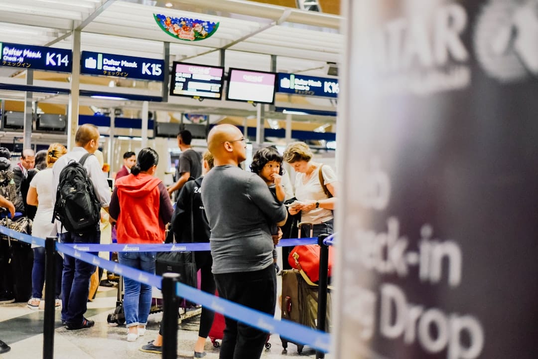 Departing overseas Filipino workers lining up at an airport immigration counter for exit clearance and OEC verification before boarding