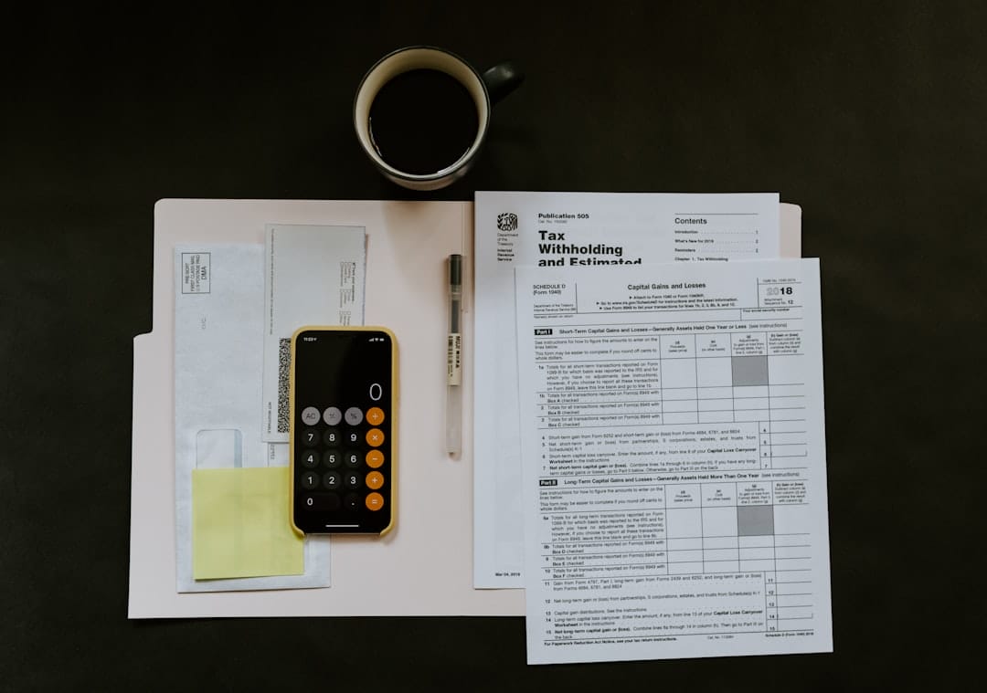 A BIR withholding tax certificate document on a desk beside a pen and smartphone, representing Philippine payroll withholding tax compliance
